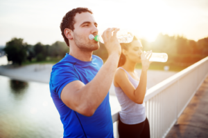 two people drinking from water bottles after being active outside for Nutrition Consulting & Lifestyle Coaching